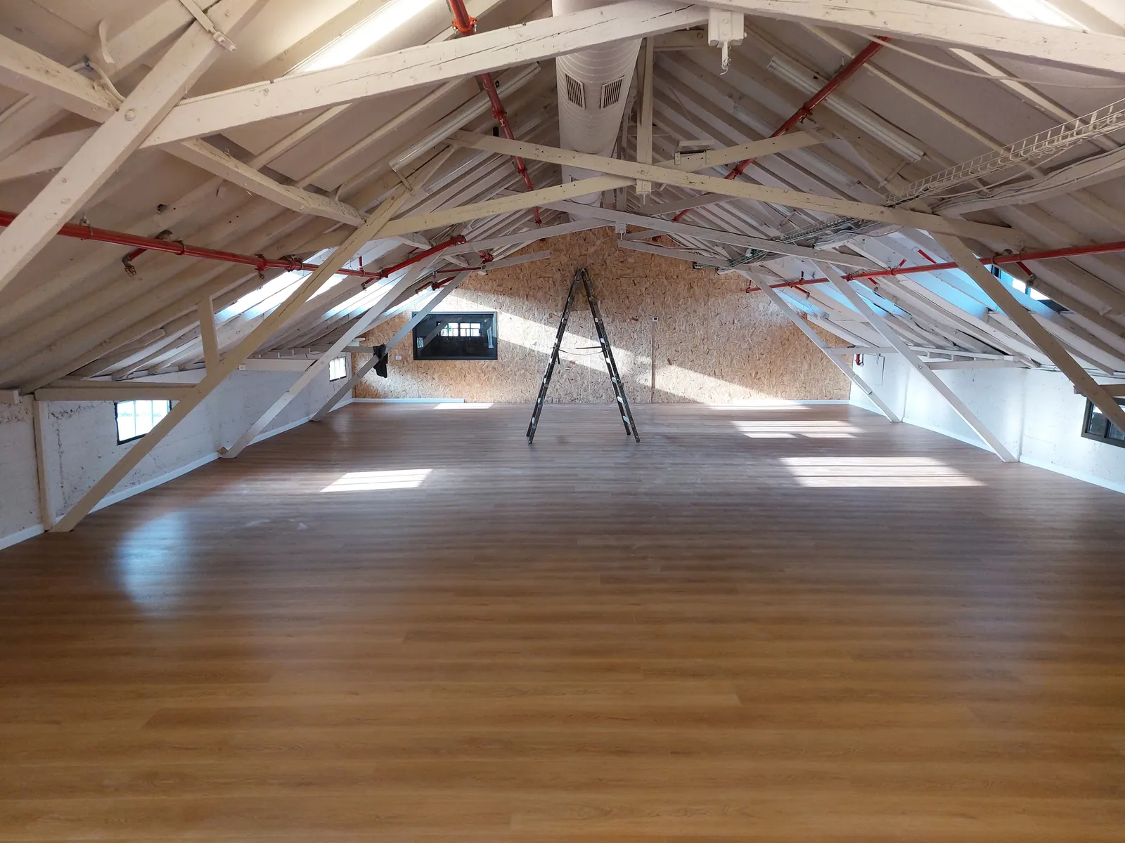 Finished wood plank floor in an attic dance studio.