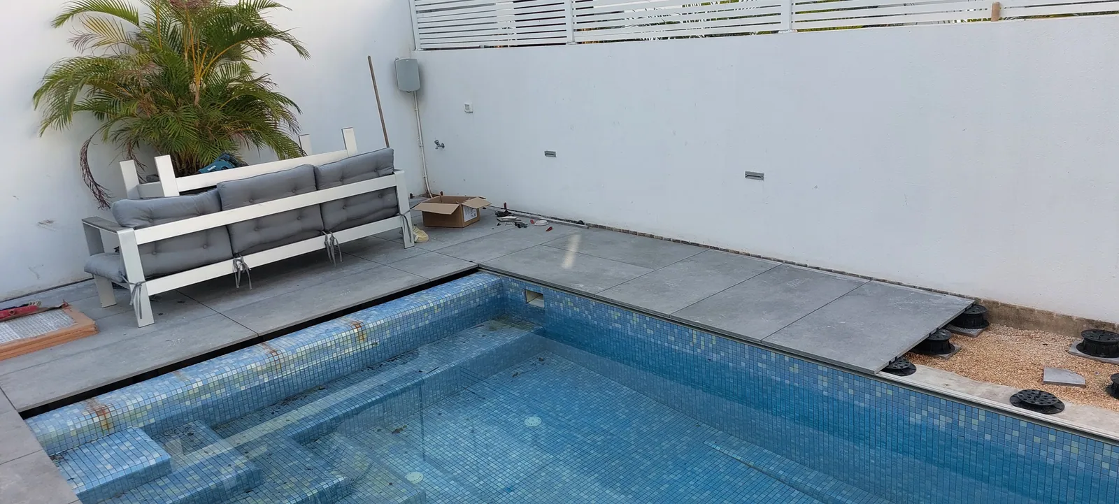 Finished pool deck with a lounge area.
