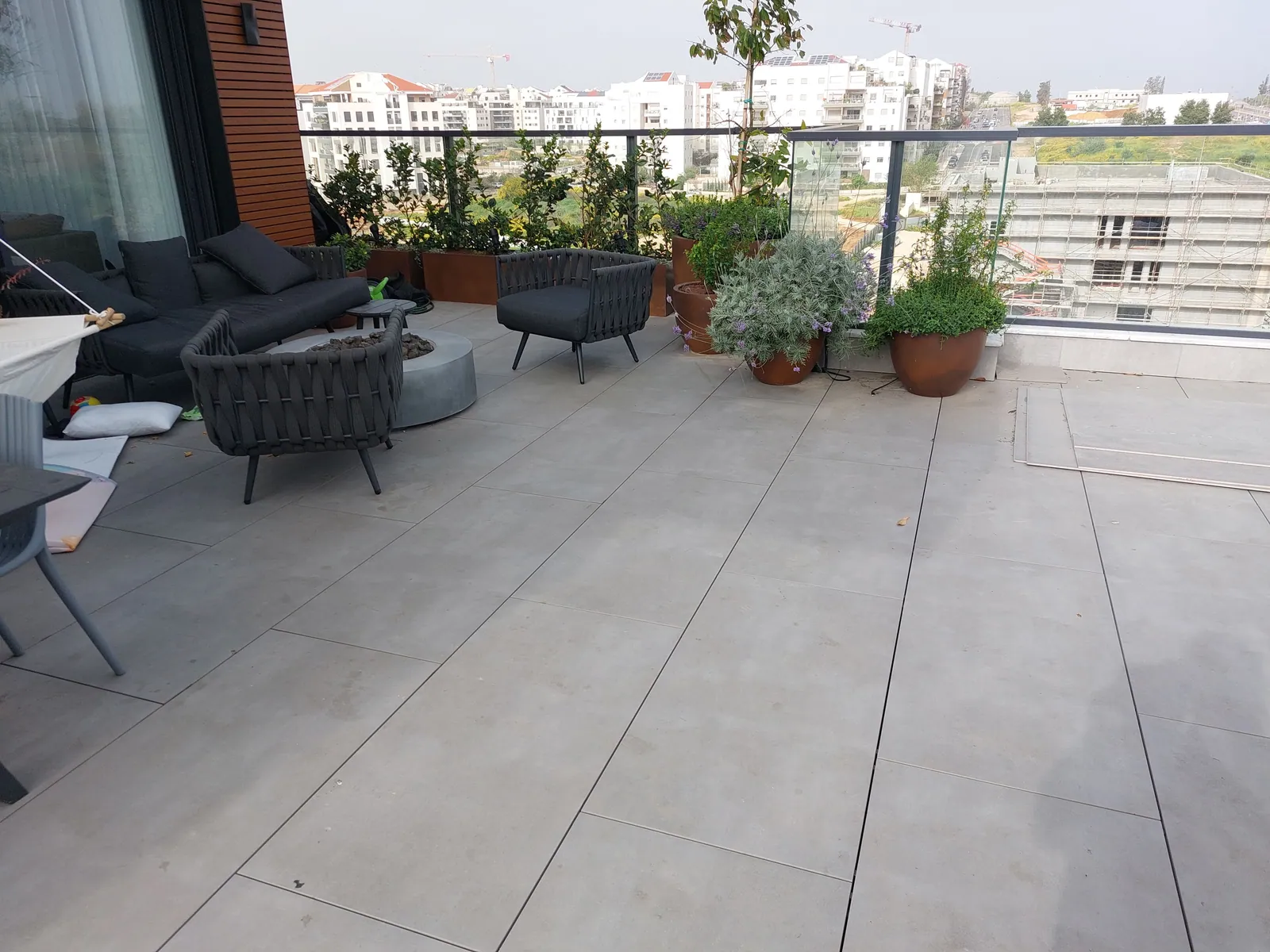 Finished terrace with outdoor furniture and potted plants.