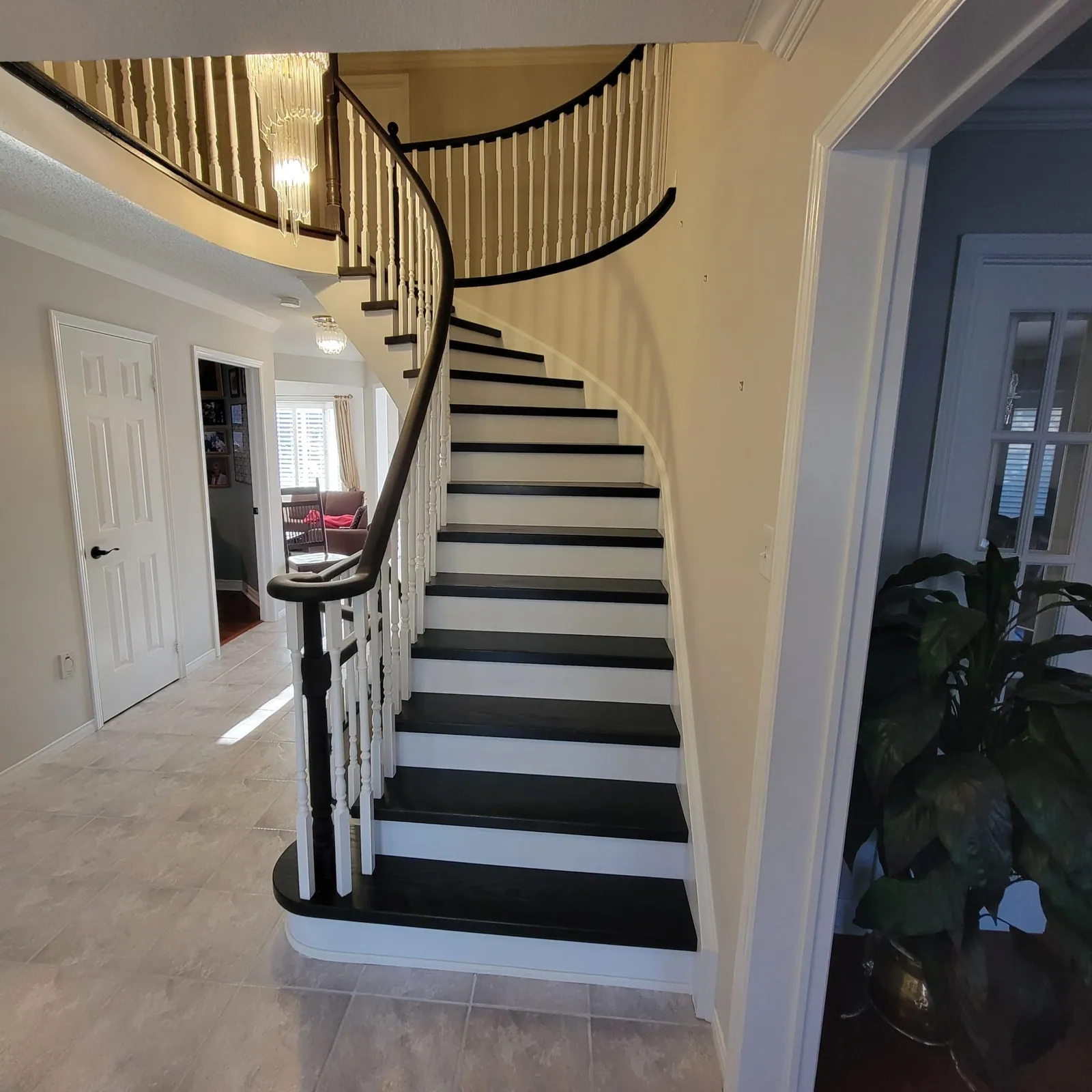 Grand curved staircase with dark treads and white risers.