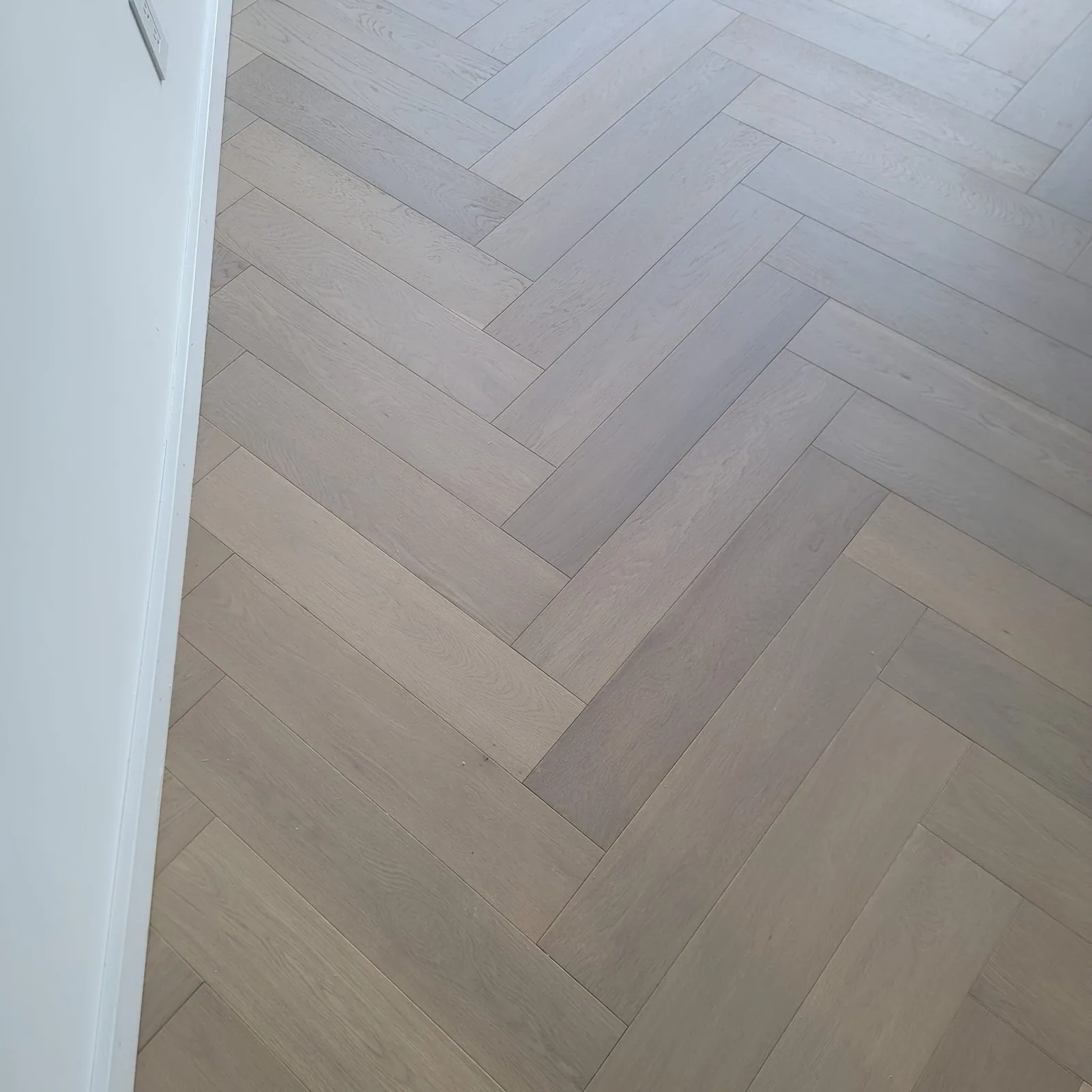 Light gray herringbone plank floor.