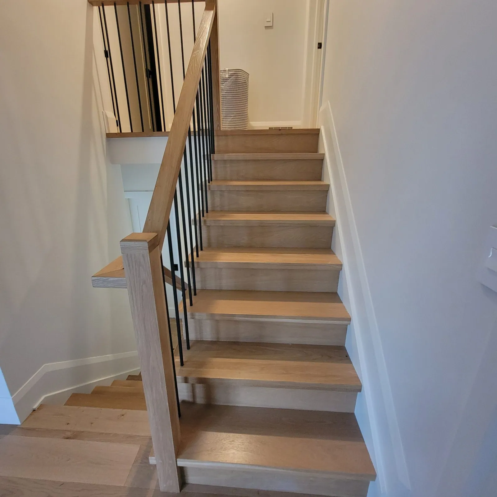 Light oak stair with a gray stained railing.