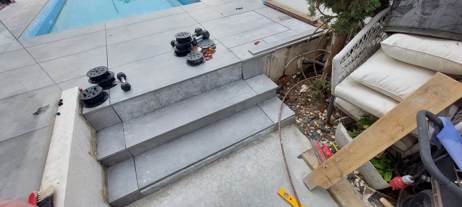 Paver steps built on pedestals down to a pool.