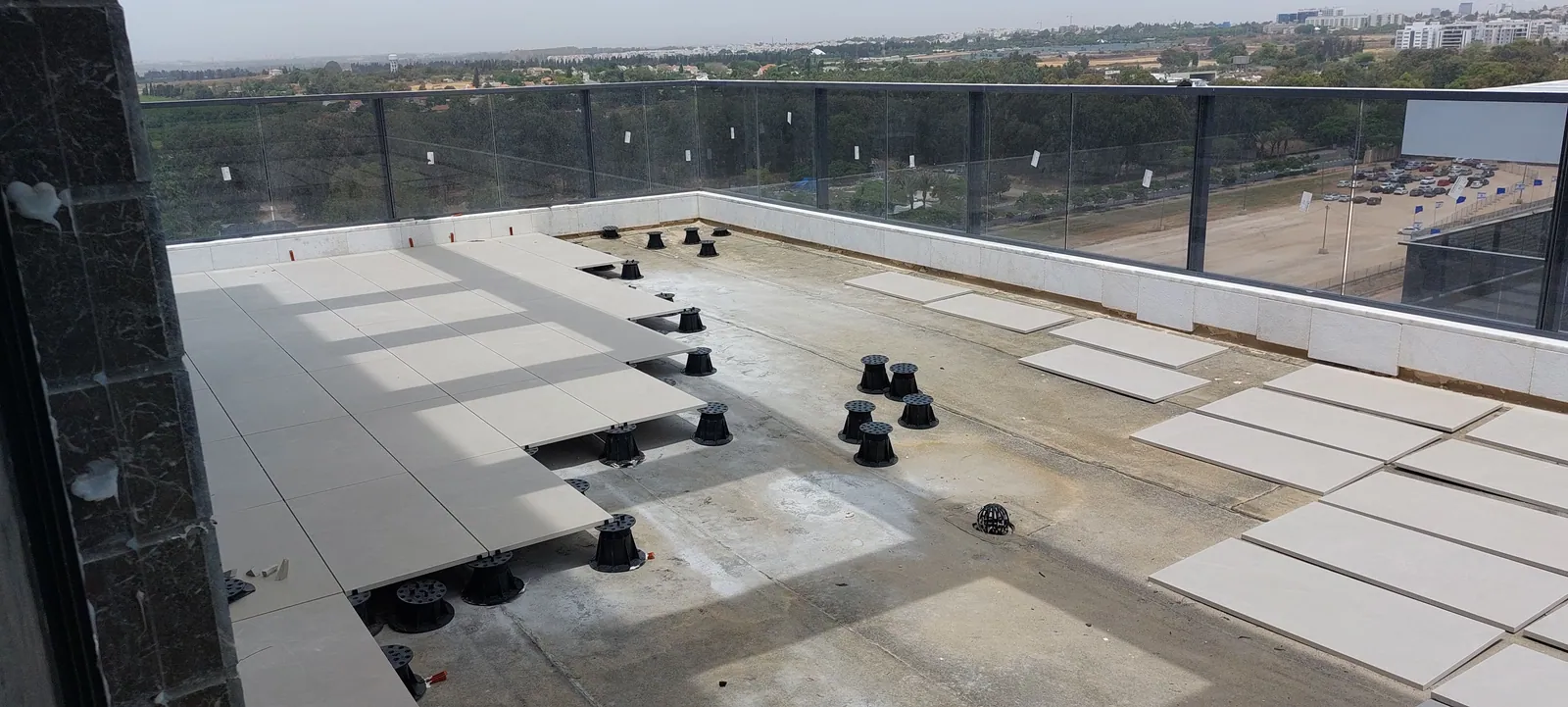 Rooftop pedestal layout with the first pavers set.