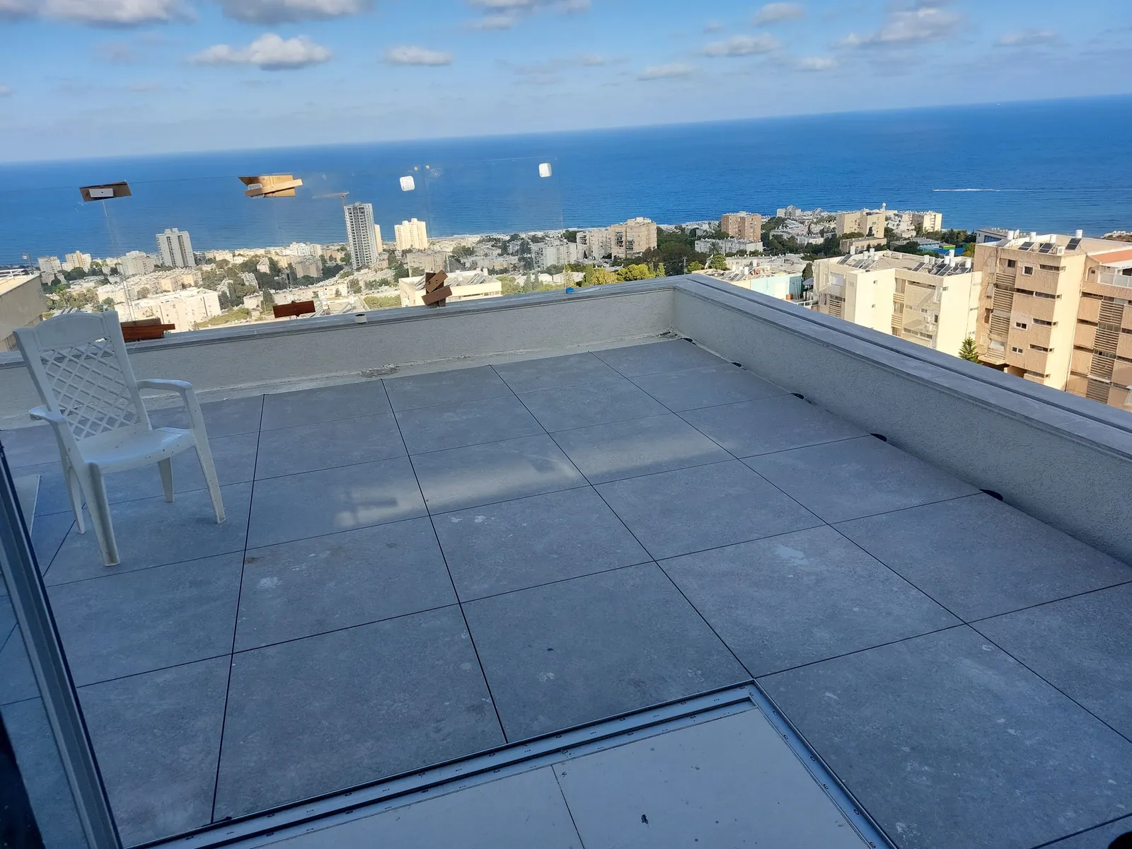 Finished rooftop terrace with large porcelain pavers on pedestals.